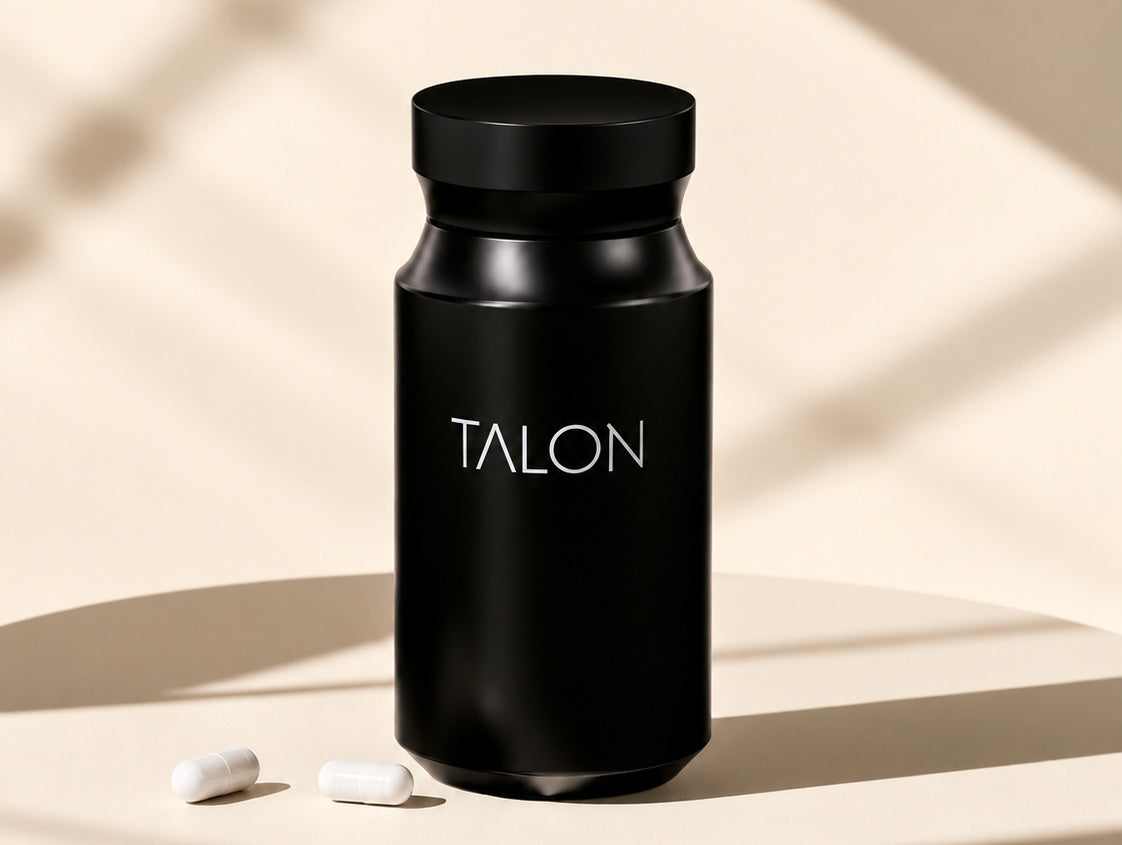 Black TALON bottle with two small white capsules in warm studio light